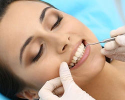 Woman having her teeth and gums examined by dentist