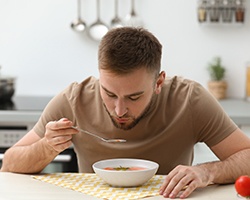 a man eating a bowl of soup