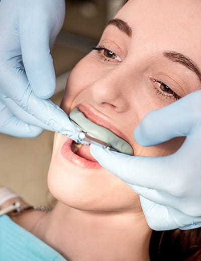 Woman in dental chair receiving fluoride treatment