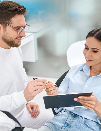 A woman consulting her dentist about treatment costs