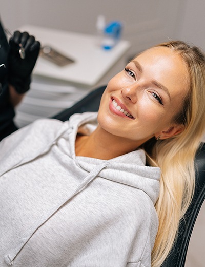 a patient smiling while visiting her dentist