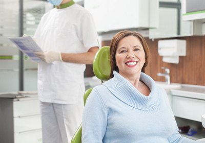 Smiling female patient in dentist’s chair