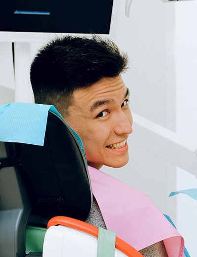 Man in dentist’s chair looking over his shoulder