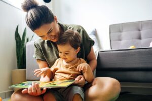 a mother holding a baby and reading him a book